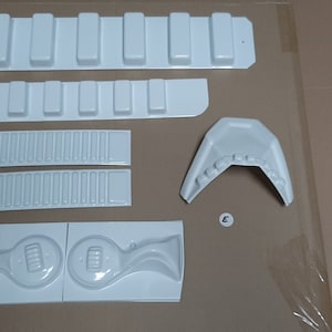 May include: White plastic moulds for making a model. The moulds are labelled A through E. The moulds are for different parts of the model, such as the body, wings, and tail.