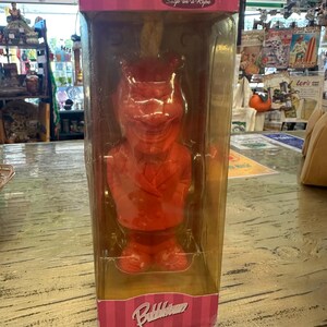 Puede incluir: Un jabón rojo con forma de diablo en una cuerda, empaquetado en una caja de plástico transparente. La caja tiene detalles a rayas rosas y blancas y las palabras "El Diablo" y "Bubbletown". La figura de jabón lleva un gorro de chef.
