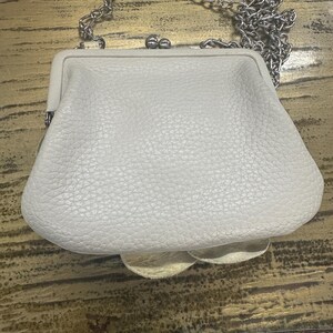 Peut inclure: Une tasse en c&eacute;ramique blanche avec une anse noire et le texte "But first, coffee" dans un style manuscrit. La tasse est sur une surface blanche. La tasse est probablement utilis&eacute;e pour les boissons chaudes.