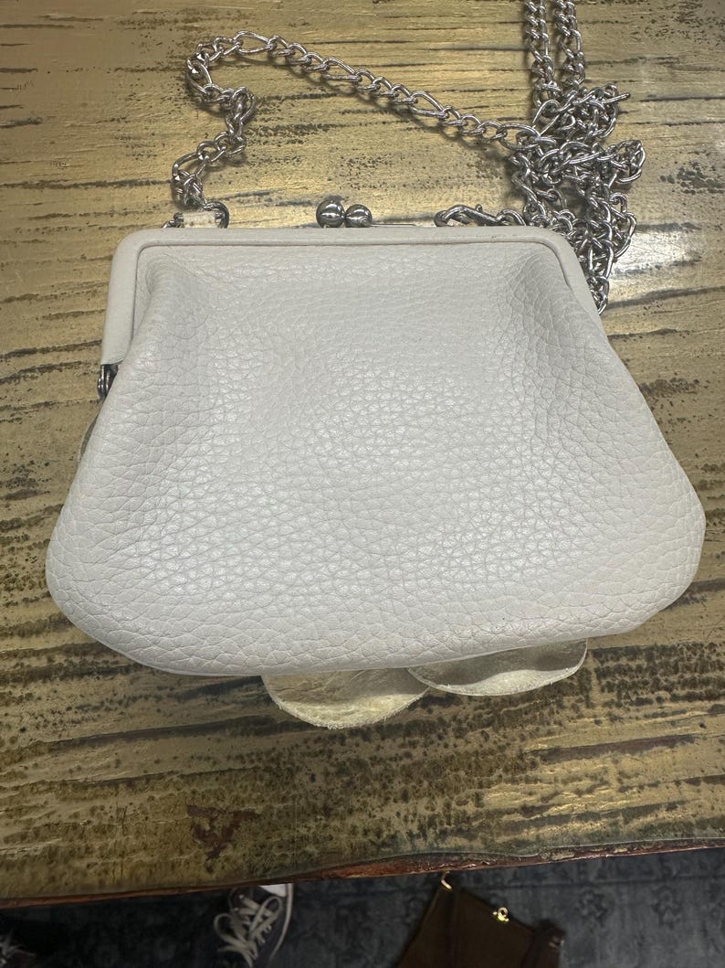 Peut inclure: Une tasse en c&eacute;ramique blanche avec une anse noire et le texte "But first, coffee" dans un style manuscrit. La tasse est sur une surface blanche. La tasse est probablement utilis&eacute;e pour les boissons chaudes.