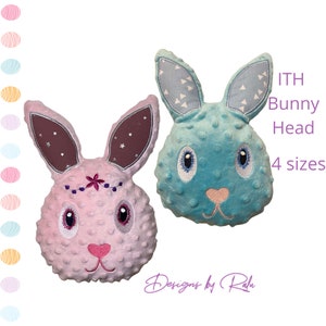 May include: Two plush bunny heads, one pink with a flower headband and the other blue with white triangle ears. The text "ITH Bunny Head 4 sizes" is visible in the image.