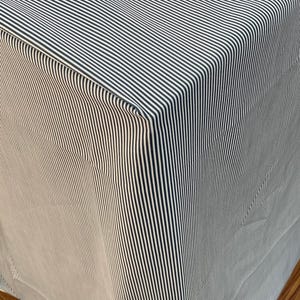 May include: A close-up of a white and black striped fabric with a folded edge. The fabric is folded to create a sharp crease.