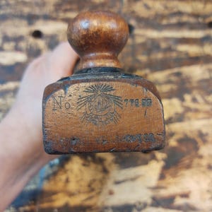 May include: A vintage wooden hand plane with a black metal blade and a wooden knob. The plane is labeled "No. 776" and "Stanley & Co."