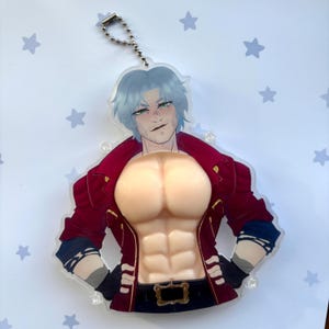 May include: A clear acrylic keychain depicting a male figure with blue hair and a red jacket. The keychain has a silver chain and a detailed illustration of the character's torso and face.