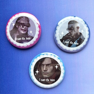 May include: Three circular pin-back badges featuring portraits of men with the text I can fix him. Each badge has a white lace-style border and small white star accents. The badges are coloured in shades of pink, blue, and light blue.