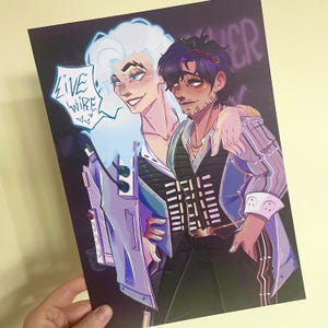 以下が含まれることがあります： 白髪と水色のジャケットの人物と、黒髪とストライプのシャツの人物のイラスト。アートワークには、吹き出しに「LIVE WIRE」というテキストが含まれています。背景は暗く、ネオン文字が描かれています。