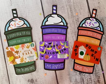 May include: Three Halloween-themed Starbucks gift cards with festive designs. The cards feature a pumpkin spice latte, a fall-themed design, and a happy Halloween banner. Each card has a personalized message and a spooky brew for you greeting.