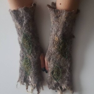 May include: A pair of brown felted fingerless gloves with green leaf embroidery.