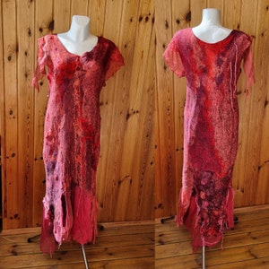 May include: A red and pink dress with a distressed, layered look. The dress has a scoop neck and short sleeves. The fabric is textured and has a slightly uneven surface.