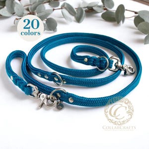 Puede incluir: Juego de correa y collar para perros de color turquesa. La correa y el collar están hechos de un material de cuerda trenzada gruesa con herrajes metálicos plateados. La imagen incluye el texto "20 colores" y la marca "COLLARCRAFTS".
