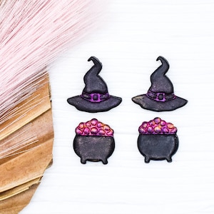 May include: Four Halloween-themed decorations: two black witch hats with purple accents and two black cauldron-shaped containers with purple accents.