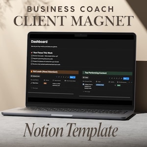 May include: A laptop screen showing a dark-themed dashboard with the text "Dashboard" and "Client Magnet." The screen displays data metrics, including "Hot Leads" and "Top Performing Content." The laptop is on a light-coloured surface.