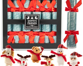 Può includere: Un set di scatole di cracker natalizi con cilindri turchesi e bianchi decorati con fiocchi rossi. La scatola è etichettata "SANTA'S FRIENDS Kuckoo Crackers". Sono presenti anche piccoli personaggi natalizi di peluche, tra cui un orso e una renna.