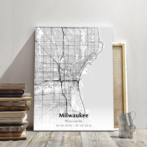 May include: A black and white map of Milwaukee, Wisconsin with the city's name and coordinates printed below. The map is printed on a white background.