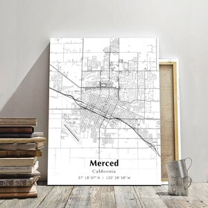 May include: A black and white map of Merced, California. The map shows the city streets and landmarks. The text "Merced, California" and the coordinates "37° 18' 07" N 120° 28' 58" W" are printed below the map.