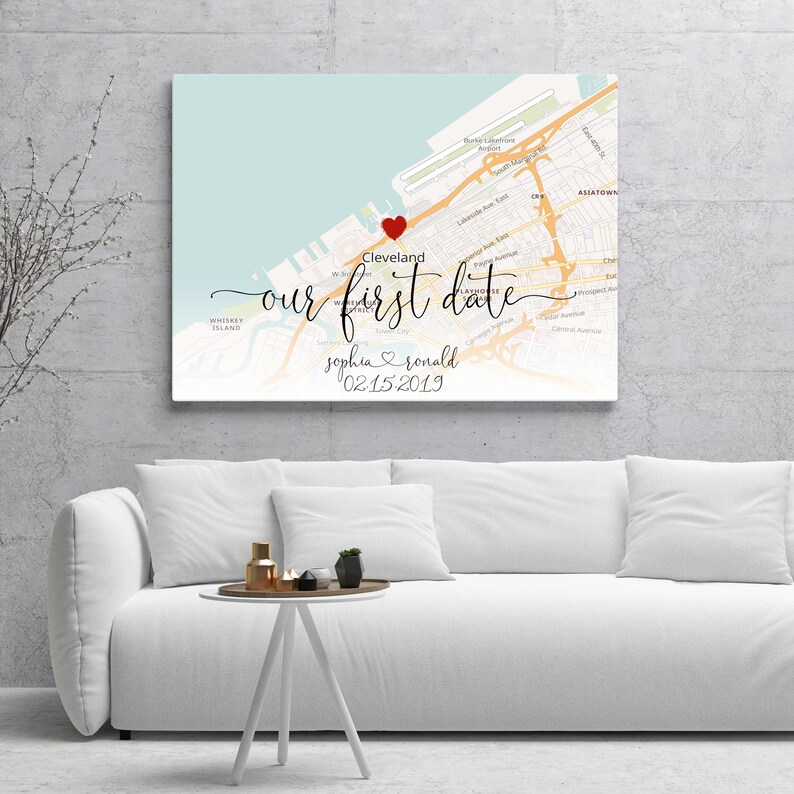Puede incluir: Una impresi&oacute;n de mapa personalizada con un coraz&oacute;n rojo que marca la ubicaci&oacute;n de Cleveland, Ohio. El texto "nuestra primera cita" est&aacute; escrito en letra cursiva, junto con los nombres "sophia & ronald" y la fecha "02.15.2019".