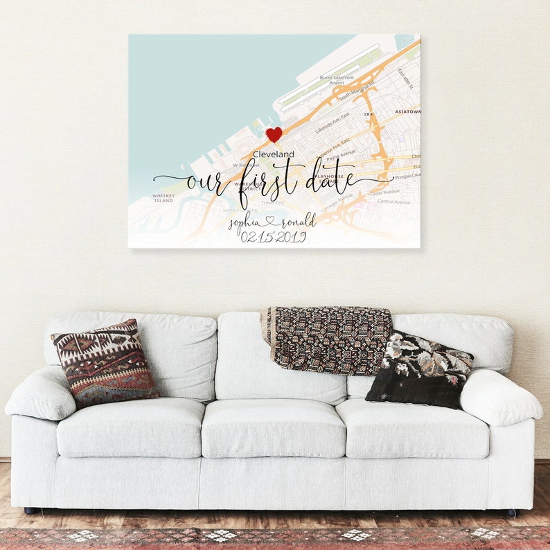 Puede incluir: Una impresi&oacute;n de mapa personalizada con un coraz&oacute;n rojo que marca la ubicaci&oacute;n de Cleveland, Ohio. El texto "nuestra primera cita" est&aacute; escrito en cursiva, junto con los nombres "sophia & ronald" y la fecha "02.15.2019".