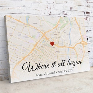 May include: A canvas print with a map of Los Angeles, California. A red heart is placed on the map where it says "Los Angeles". The text "Where it all began" is written in cursive below the map. The text "Adam & Laurel - April 13, 2019" is written below the cursive text.