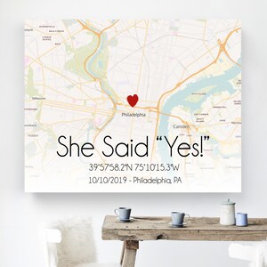 May include: A map of Philadelphia, Pennsylvania with a red heart marking the location of the city. The text "She Said "Yes!" 39&deg;57'58.2"N 75&deg;10'15.3"W 10/10/2019 - Philadelphia, PA" is printed below the map.