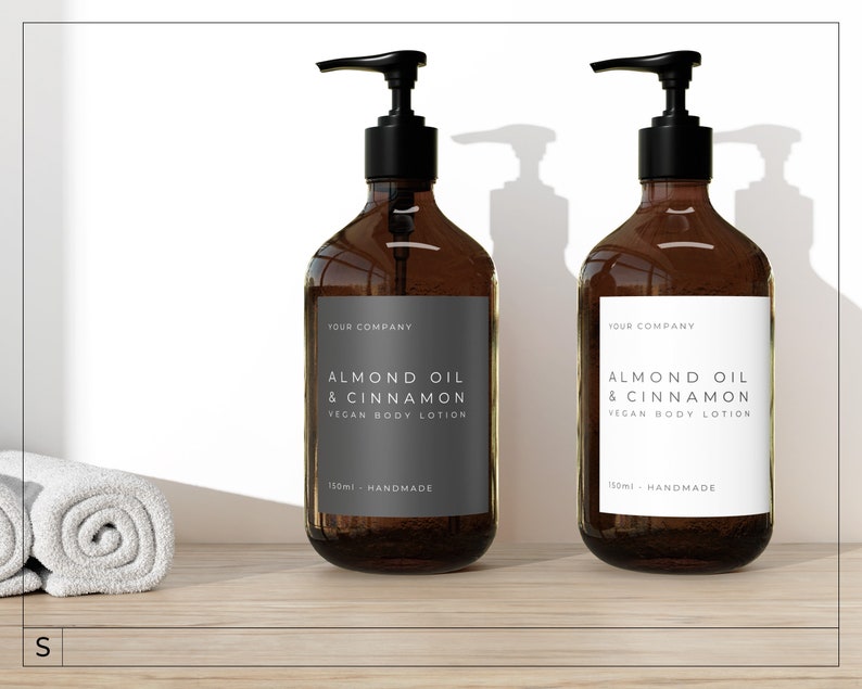 May include: Two amber glass bottles with pumps, each containing a vegan body lotion. The bottles have white labels with black text that reads "Almond Oil & Cinnamon Vegan Body Lotion" and "150ml Handmade".