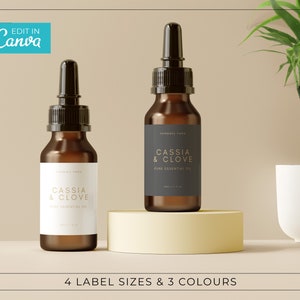 May include: Two amber glass bottles with dropper tops and white labels. The labels have black text that reads "CASSIA & CLOVE PURE ESSENTIAL OIL". The bottles are on a light yellow platform.