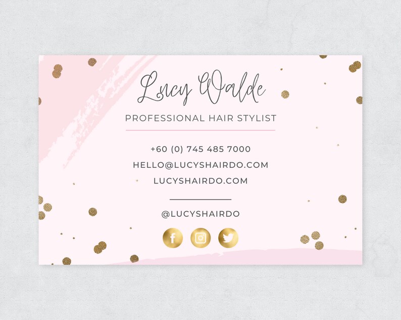 Puede incluir: Una tarjeta de visita rosa y dorada con el nombre "Lucy Walde" y el t&iacute;tulo "Estilista de cabello profesional". La tarjeta tambi&eacute;n incluye un n&uacute;mero de tel&eacute;fono, una direcci&oacute;n de correo electr&oacute;nico, una direcci&oacute;n de sitio web y identificadores de redes sociales.