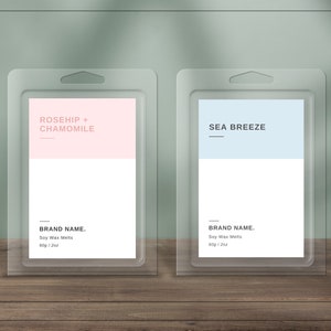 May include: Two clear plastic packaging containers with labels. The left container has a pink label with the text "ROSEHIP + CHAMOMILE" and the text "BRAND NAME. Soy Wax Melts 60g / 2oz". The right container has a light blue label with the text "SEA BREEZE" and the text "BRAND NAME. Soy Wax Melts 60g / 2oz".