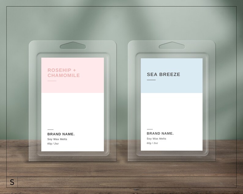 May include: Two clear plastic packaging containers with labels. The left container has a pink label with the text "ROSEHIP + CHAMOMILE" and the text "BRAND NAME. Soy Wax Melts 60g / 2oz". The right container has a light blue label with the text "SEA BREEZE" and the text "BRAND NAME. Soy Wax Melts 60g / 2oz".