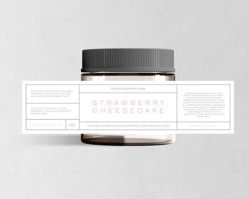May include: A glass jar with a black lid and a label that reads "STRAWBERRY CHEESECAKE" in pink lettering. The label also includes the text "YOUR COMPANY NAME" and lists ingredients for a handmade skin care product.