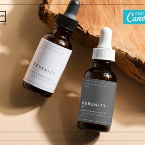 May include: Two amber glass bottles with dropper tops, labeled "SCENTSATIONAL CO" and "SERENITY ROSE & VANILLA BLISS 100% NATURAL ESSENTIAL OIL 1 OZ", sitting on a piece of wood.