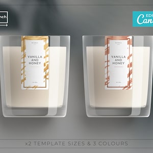 Puede incluir: Dos tarros de velas de vidrio con cera blanca y etiquetas. Las etiquetas tienen diseños abstractos dorados y marrones y el texto "Vainilla y Miel".