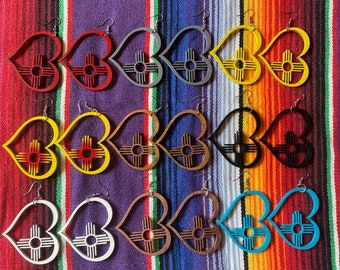 May include: A set of 10 pairs of heart-shaped earrings with a stylized sun symbol inside. The earrings are made of wood and come in a variety of colors, including red, yellow, brown, black, white, and blue.