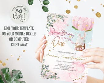 Può includere: Un invito di primo compleanno rosa e bianco con un'illustrazione ad acquerello di un coniglio in una mongolfiera. Il testo recita "Some Bunny is turning One" e include il nome del bambino, la data, l'ora e le informazioni RSVP.