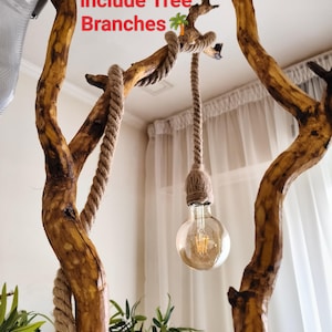 Może przedstawiać: Rustykalna lampa podłogowa lub sufitowa z dużą, odsłoniętą żarówką zawieszoną na grubej linie. Lampa jest podtrzymywana przez naturalnie wyglądające, brązowe gałęzie drewniane. Tekst na zdjęciu brzmi "Does NOT include Tree Branches" i "Rope Floor Lamp or Ceiling."