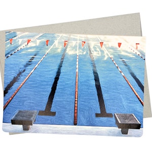 May include: A swimming pool with eight lanes, red and white lane markers, and two starting blocks. The pool is blue and the water is clear.