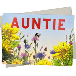 May include: A greeting card with the word "AUNTIE" in red letters on a blue background. The card features a variety of colorful wildflowers and a bee.
