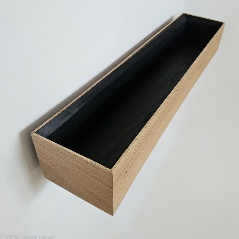 Op de afbeelding: Een rechthoekig houten plank met een natuurlijke houten buitenkant en een zwart interieur. De plank is aan een witte muur bevestigd en toont zijn strakke lijnen en minimalistische design. De plank is ongeveer 76 cm lang.