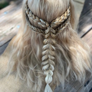 May include: A blonde wig with a braided crown and a single braid hanging down the back.