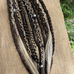 Peut inclure: Un ensemble d'extensions de cheveux synthétiques brunes et blondes avec des perles et des breloques. Les extensions sont tressées et ont une variété de textures.