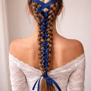 May include: A long, braided hairstyle with blue ribbon woven through the braid. The hair is a light brown color. The braid is tied at the bottom with a blue ribbon. The person is wearing a white lace dress.