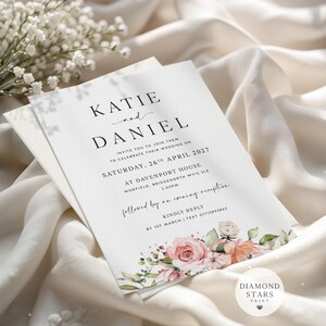 May include: A white wedding invitation card featuring black serif and script typography with the names Katie and Daniel. The card includes floral illustrations of pink and peach roses at the bottom and text details for a wedding on 26th April 2027.