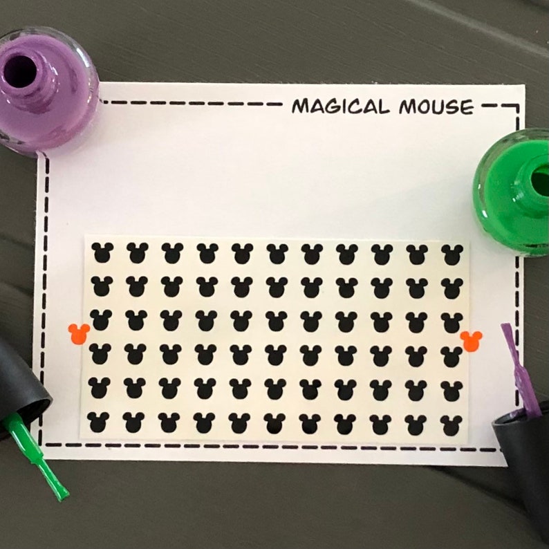 May include: A sheet of black Mickey Mouse head stickers on a white background. The sheet is labeled "Magical Mouse".