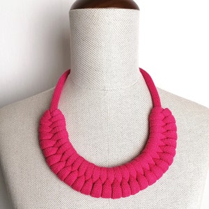 Puede incluir: Un collar de cuerda trenzada de color rosa brillante. El collar est&aacute; hecho de una cuerda gruesa y suave y est&aacute; dise&ntilde;ado para sentarse alto en el cuello.