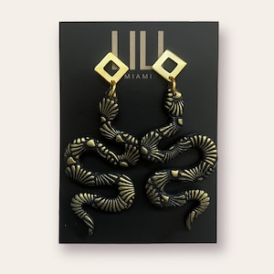 Black and gold dangle snake earrings made from polymer clay