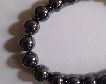 May include: A black beaded bracelet with shiny, round beads.