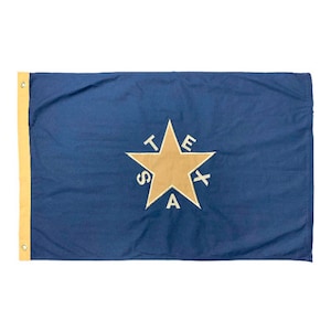 May include: A blue flag with a gold star and the word "TEXAS" spelled out around the star in white.