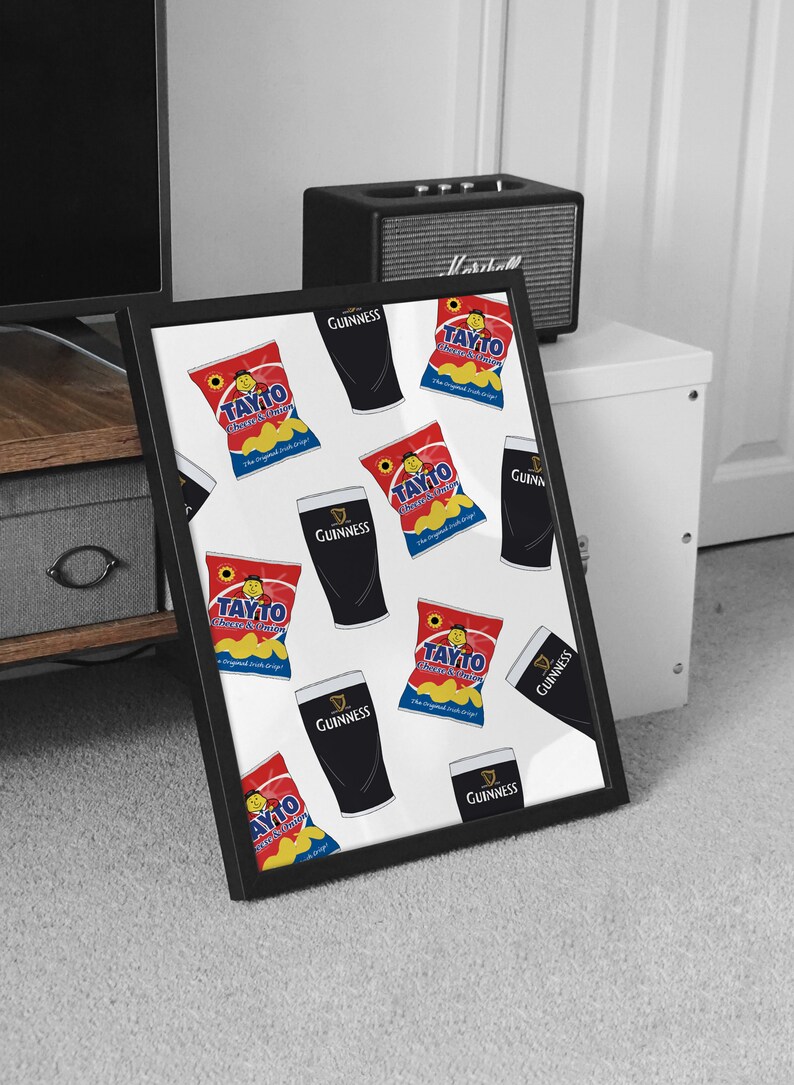 May include: A framed print with a white background and a repeating pattern of black Guinness pint glasses and red and yellow Tayto Cheese & Onion crisps bags. The text "Tayto Cheese & Onion" and "Guinness" is visible on the bags and glasses.