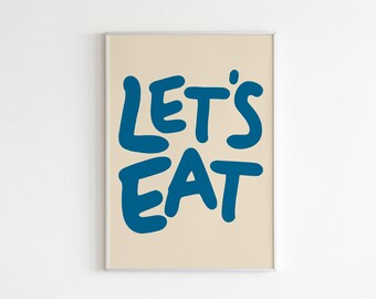 Puede incluir: Una impresión artística enmarcada con las palabras "LET'S EAT" en letras negritas de color azul oscuro. El texto está centrado sobre un fondo beige claro. La impresión está en un marco plateado y se muestra contra una pared blanca.