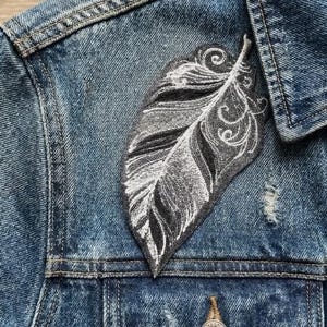 May include: A white ceramic mug with a black handle and the text "But First, Coffee" in a black, handwritten-style font. The mug is on a white surface.