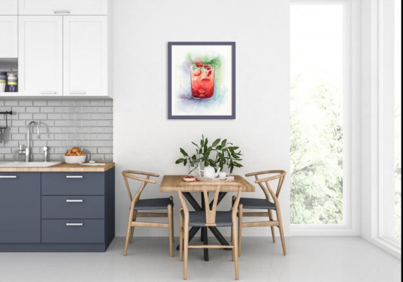 May include: A watercolor painting of a glass of red drink with ice and mint leaves. The painting is framed and hanging on a white wall in a dining room.